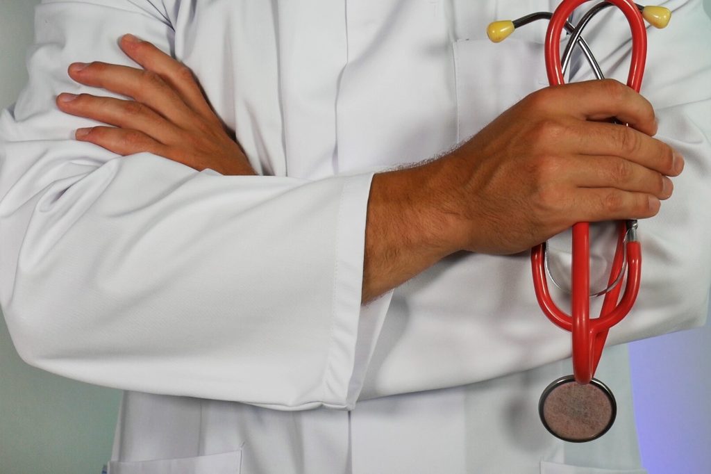 close up of doctors arms holding stethoscope