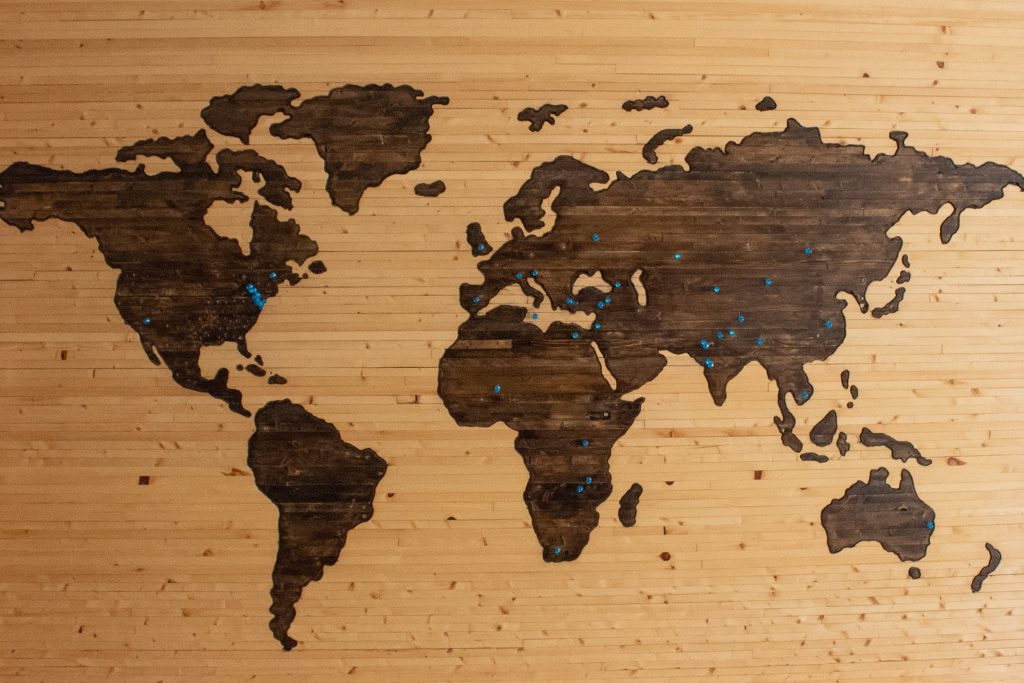 Wooden map of the world with pins