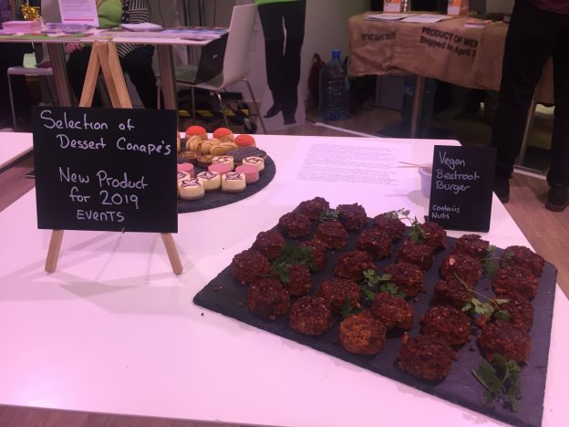 Table with selection of Gulbenkian cakes and vegan beetroot burgers