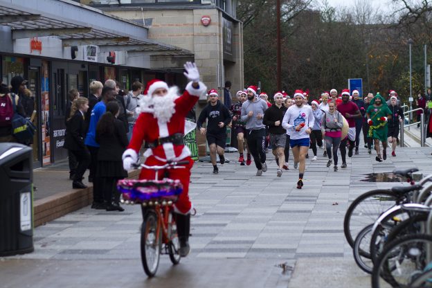cyclist and runners dressed up as santa