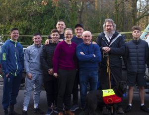 Boxer Barry Mcguigan in a group photo with seven other men and a guide dog, getting ready to take on the Row Britannia challenge.