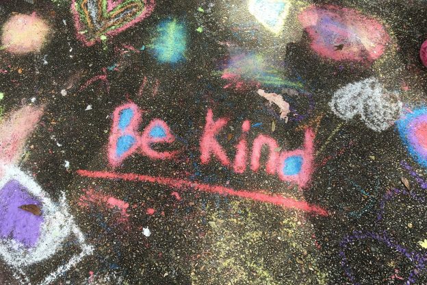 Be kind written in coloured chalk on a chalkboard