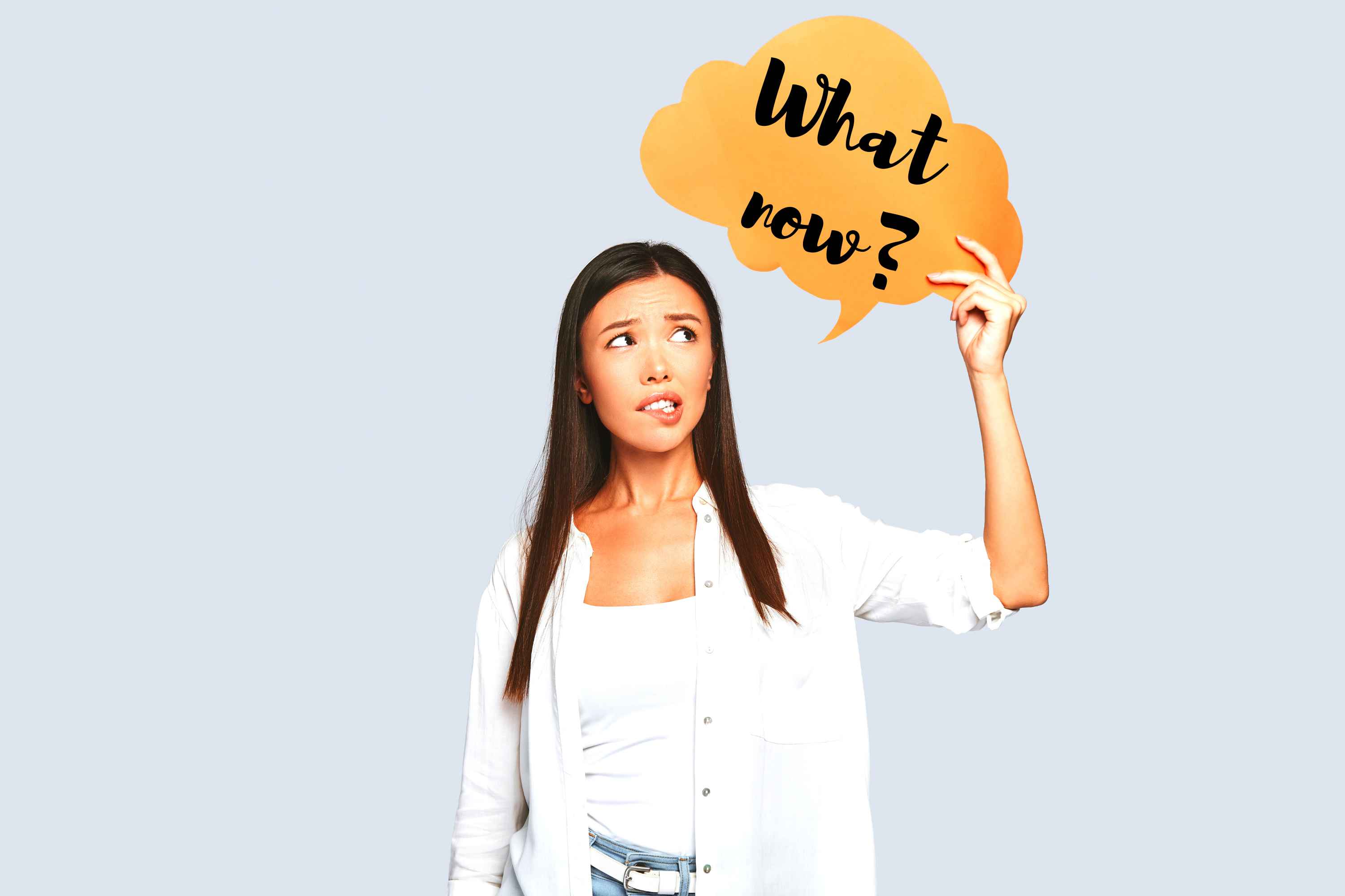 Woman holding speech bubble that says "What now?"