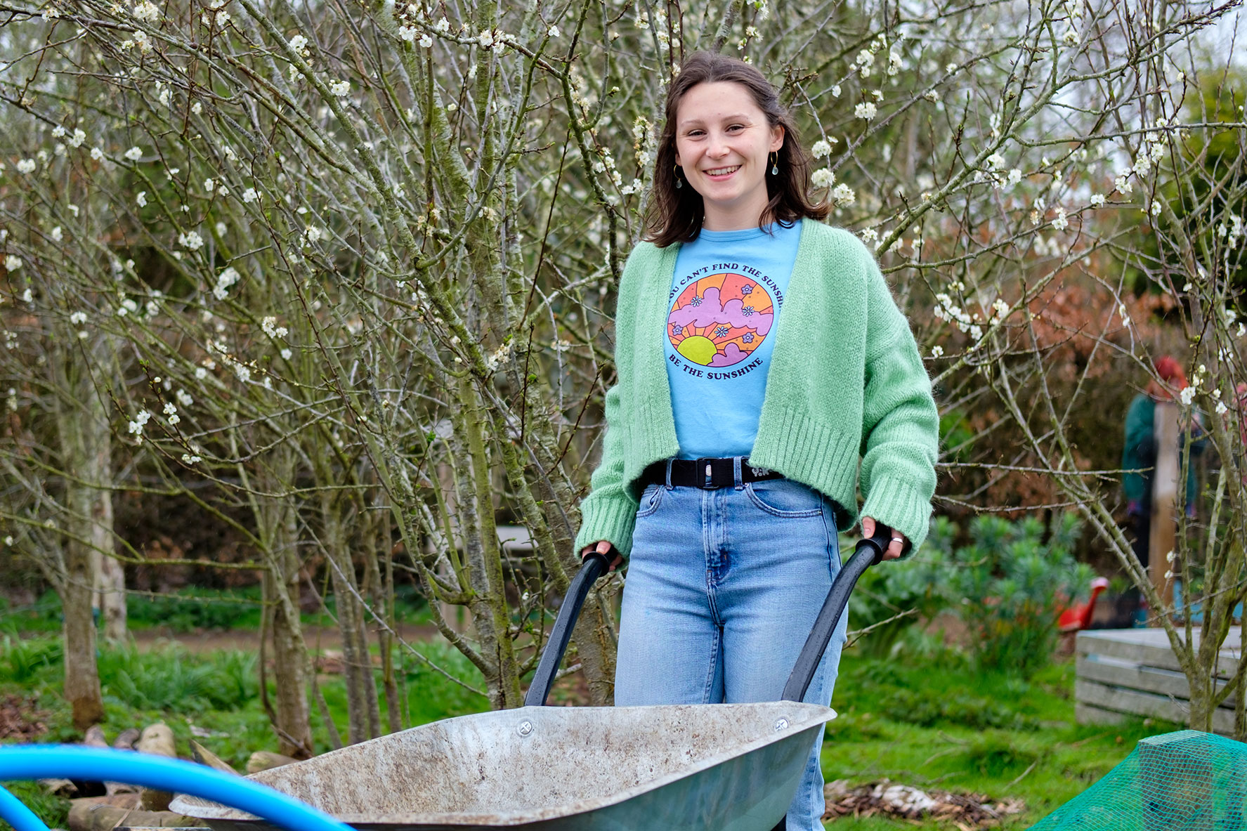 Student Bella pushing wheel barrow in Kent Community Oasis Garden