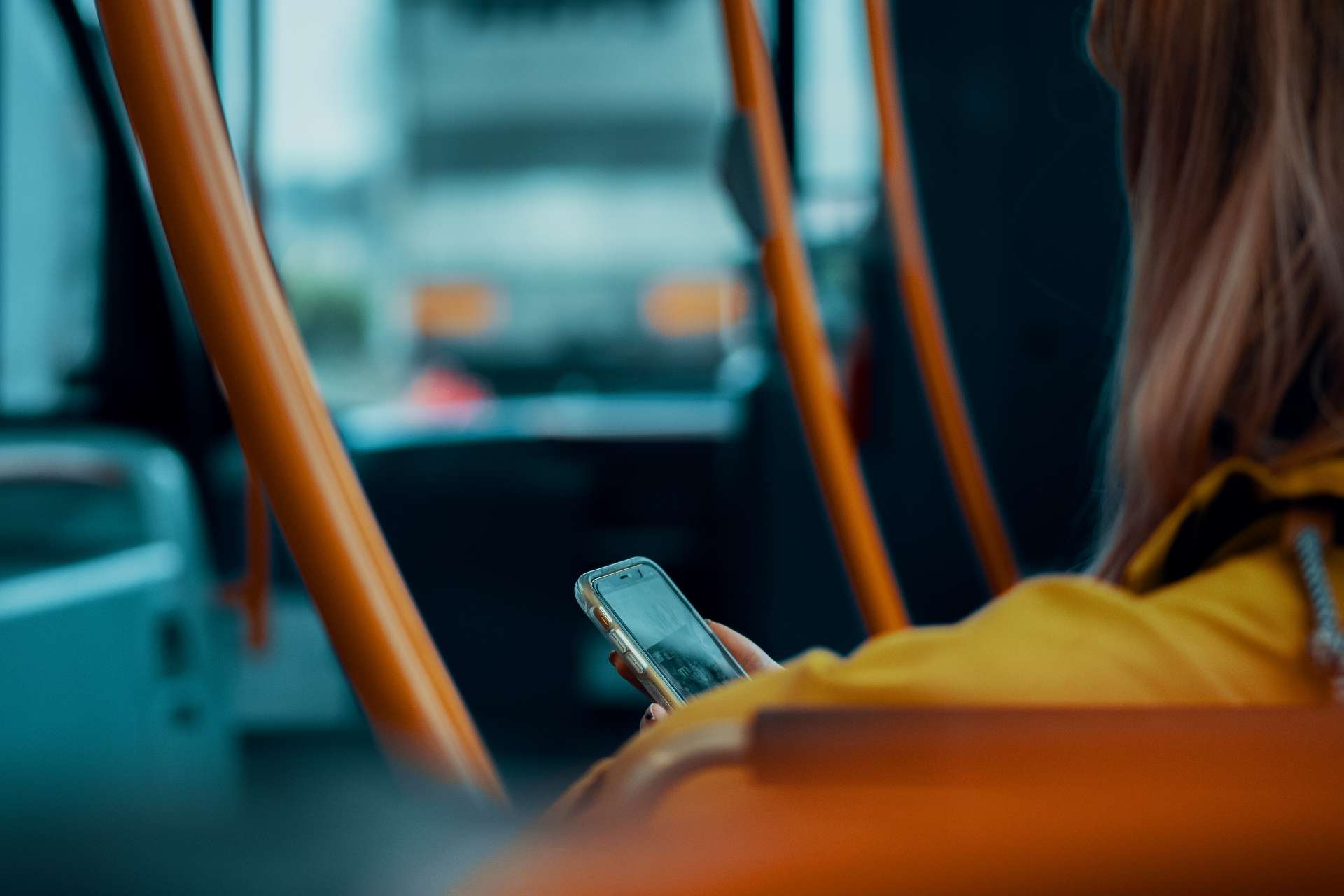 student looking at phone on bus