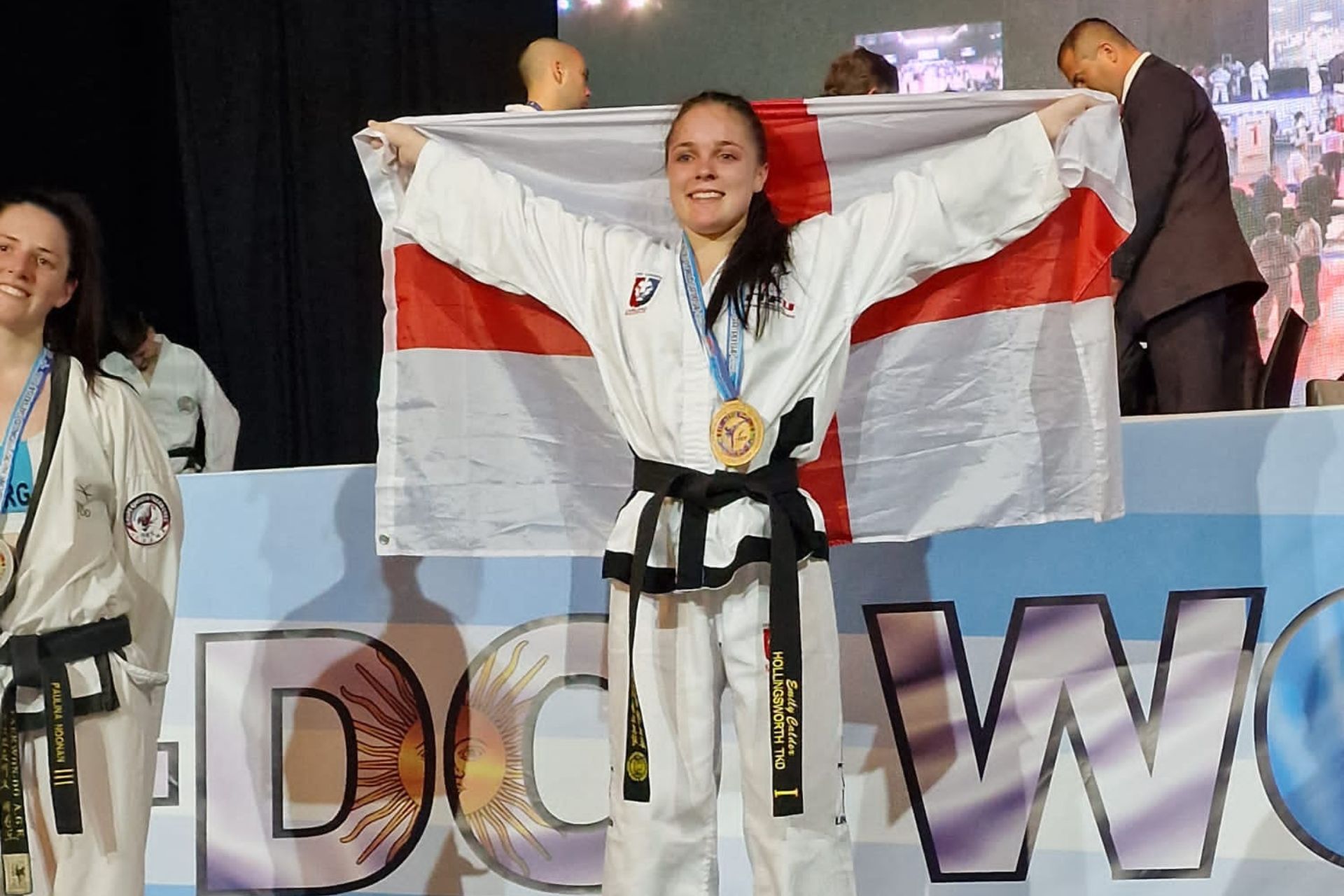 Student Emily wearing gold medal holding England flag