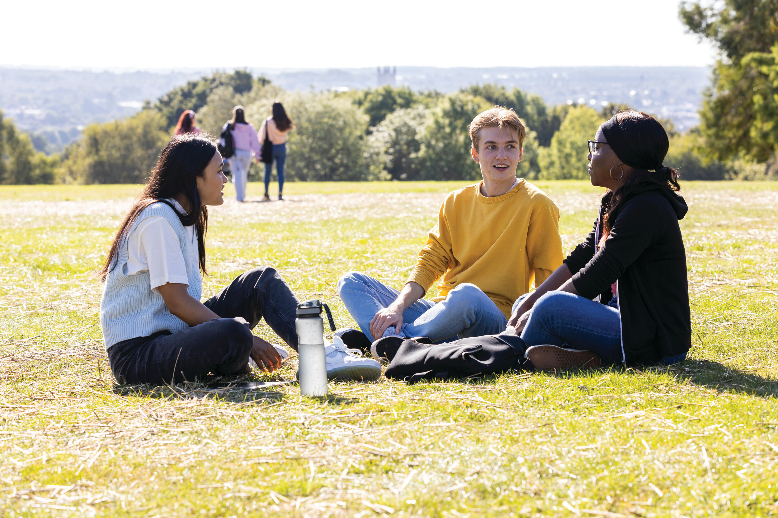 Three students sitting and talking on campus