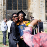 Black female graduate posing for photo at graduation ceremony