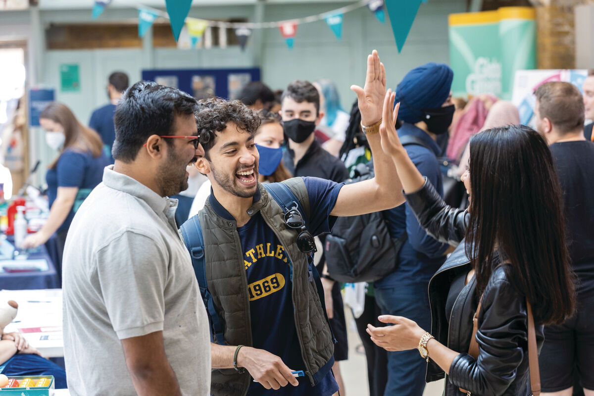 Students high-fiving at welcome fair