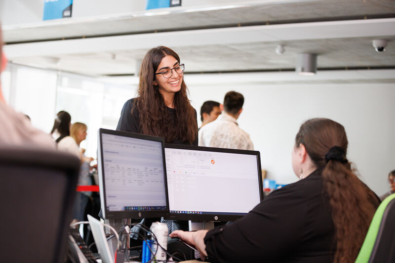 student talking to support staff on pc