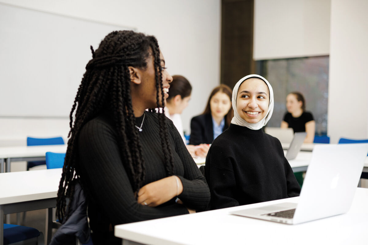 Two students smiling at each other