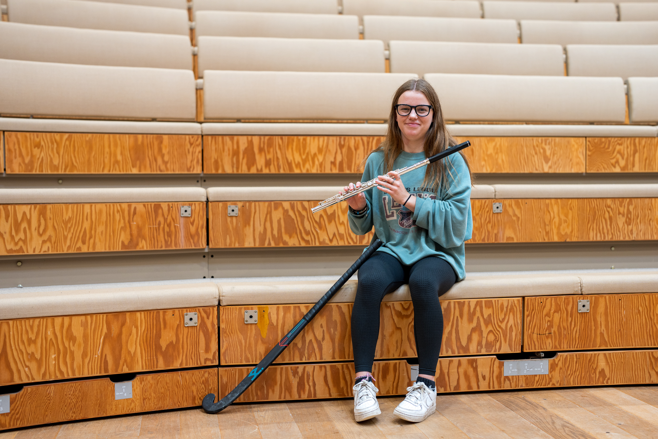 Kent Star Heather holding flute with hockey stick resting by her side