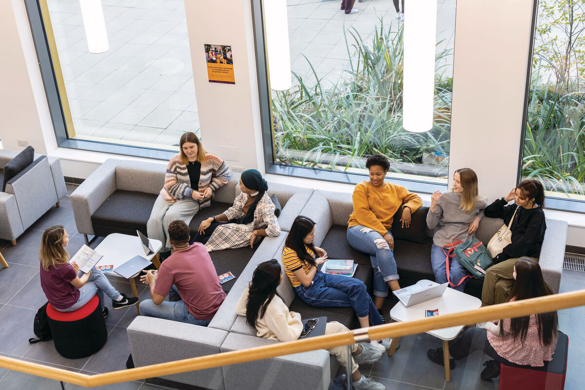 Lots of students sat chatting on sofas