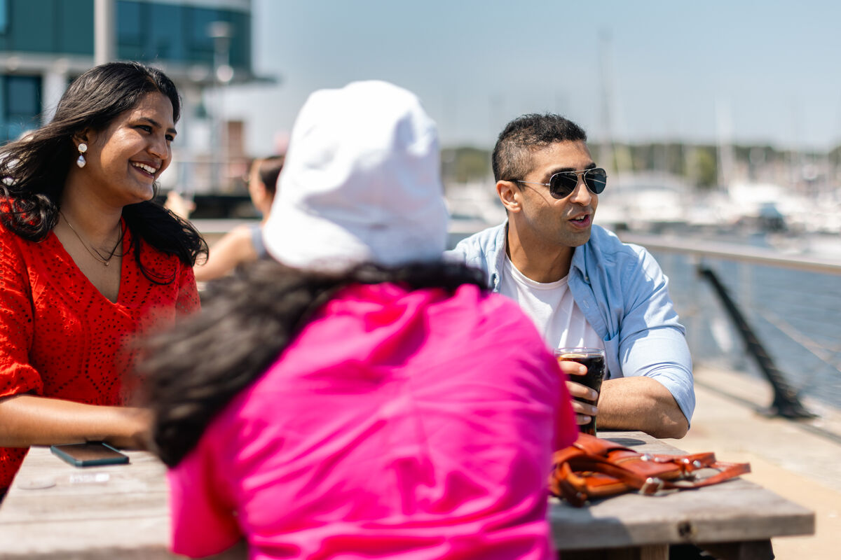 Students sitting by dock in Medway