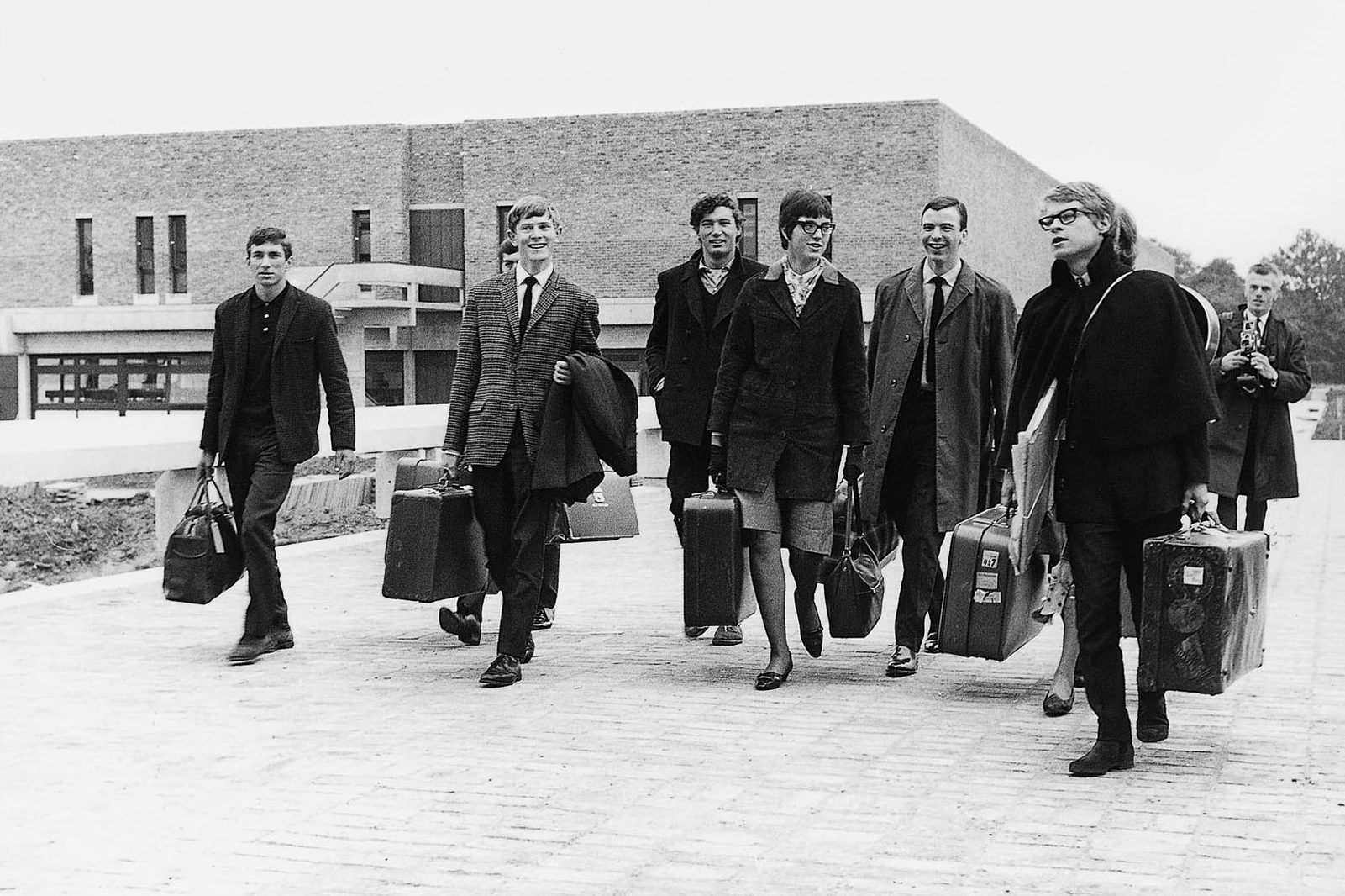 Black and white photo of some of Kent's first students walking together with their suitcases