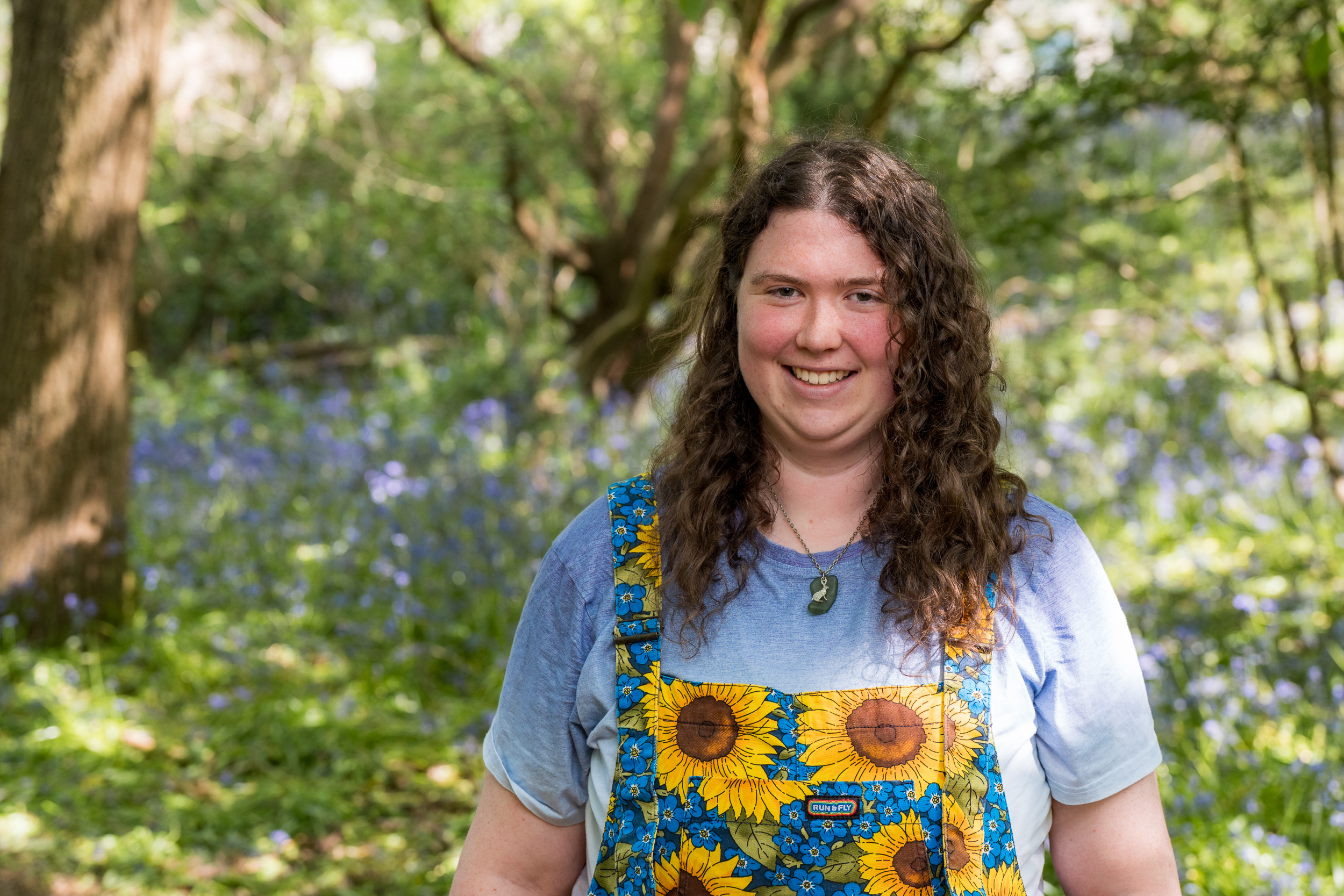 Elinor smiling with bluebells behind her