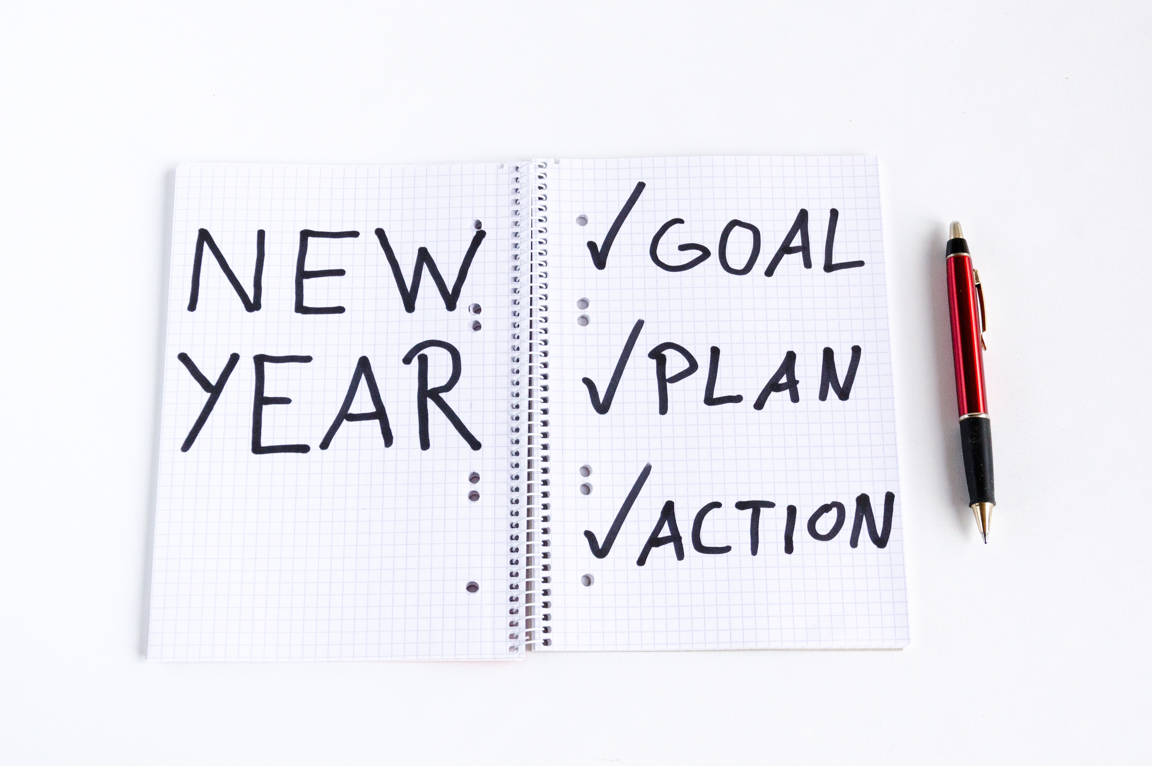 open note book with words 'New Year' and a tick list of 'goal; plan; action'