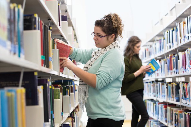 Students selecting books in library