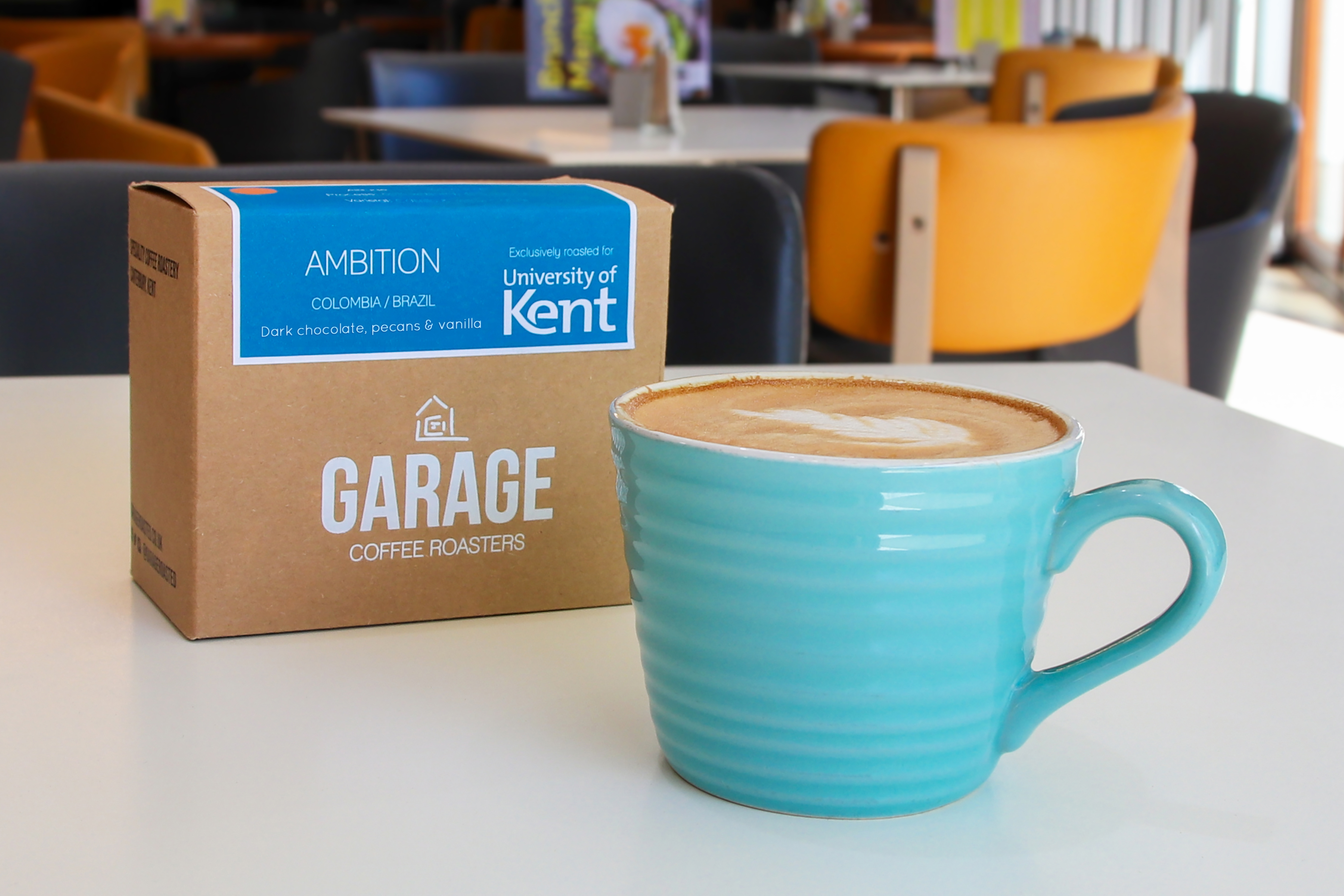 A box of Garage Coffee Ambition coffee beans next to a cup of coffee