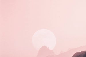 a pinkish sunset over mountains